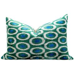 a green and white pillow with blue circles on the front, sitting on a white background