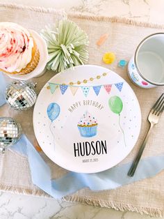 a personalized birthday plate with cupcakes and balloons on it next to other decorations