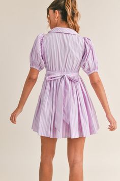 This pinstripe dress features short puff sleeves, a v-neck collared neckline, and a self tie and button front detail. The versatile tie can be styled in the front or the back, giving you different looks for any occasion. Made from high-quality materials, this dress offers both comfort and style. Chic Striped Short Sleeve Mini Dress, Chic Striped Mini Dress With Short Sleeves, Preppy Short Sleeve Spring Dresses, Fitted Short Sleeve Dress With Striped Collar, Spring Striped Collared Dress, Summer Dress With Striped Collar And Short Sleeves, Fitted Short Sleeve Dress With Vertical Stripes, Fitted Dress With Vertical Stripes And Short Sleeves, Collared Striped Mini Dress For Spring