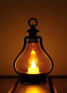 a lit candle sitting on top of a wooden table