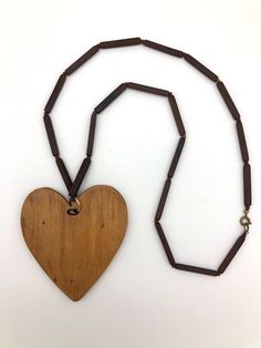 "If you're a child of the 60's you might remember pendant necklaces! This hippie era necklace features a wooden hand carved heart, approximately 3\" x 3\", with a \"Chain\" made of 1.25\" wooden rectangular shape beads and small round beads as spacers. I wore this necklace proudly when I was young. It measures 16\" long, and is in excellent condition, certain to bring back memories of the 60's and 70's! Groovy" Retro Brown Necklace For Gift, Handmade Brown Heart Pendant Necklace, Vintage Brown Heart-shaped Jewelry, Brown Heart-shaped Bohemian Necklace, Bohemian Brown Heart-shaped Necklace, Brown Bohemian Heart Necklaces, Brown Heart Pendant Necklace For Valentine's Day, Brown Heart-shaped Necklace For Valentine's Day, Brown Heart Necklace For Valentine's Day