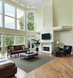 a living room filled with lots of furniture next to large windows and a fire place