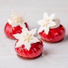 three small red vases with white flowers on them