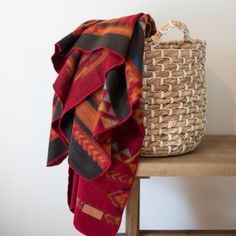 a basket and blanket sitting on top of a wooden table