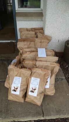 several bags of coffee sitting on the ground in front of a building