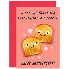 two toasted breads with happy faces on them are shown in front of an anniversary card