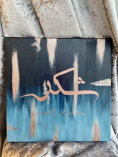 a painting on the side of a building with an arabic calligraphy painted on it