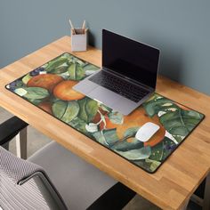 an open laptop computer sitting on top of a wooden desk next to a mouse pad