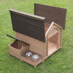 a wooden dog house with two bowls in it