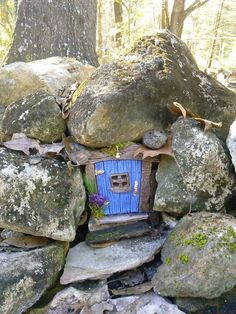 a rock wall with a small blue house built into it