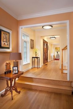 an entry way with stairs and pictures on the wall