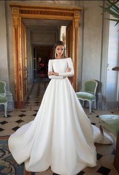 a woman in a white wedding dress posing for the camera