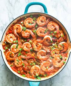 a pot filled with shrimp and vegetables on top of a table