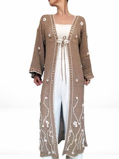 Sakura is a unique, hand-crocheted, and hand-embroidered duster cardigan, perfect for summer days. Crafted from premium cotton yarn, this sustainable piece has just landed in BALSTROND's slow-fashion knitwear collection. With its elegant straight silhouette, wide long sleeves, sheer geometrical pattern, and versatile camel colour, this lace summer coat is an exquisite addition to any wardrobe. Adorned with delicate sakura blossoms and delicate beading, it is truly a one-of-a-kind, eye-catching i Crochet Kimono Cardigan, Sakura Blossoms, Summer Coat, Fashion Knitwear, Knitwear Collection, Summer Coats, Geometrical Pattern, Embroidered Cardigan, Knitwear Fashion