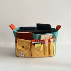 a purse that is filled with lots of items and has some pens, pencils, and other things in it