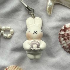 a keychain with a bunny holding a donut in it's lap