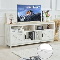 a flat screen tv sitting on top of a white entertainment center in a living room