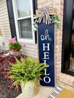 a blue sign that says oh helo on it next to a potted plant