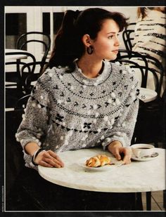 a woman sitting at a table with food in front of her and looking off to the side