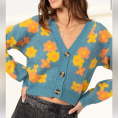 Cropped Teal Cardigan With Yellow And Orange Daisy Print. V Neckline. Button Down Center. Soft Thick Sweater Material. Trendy Blue Cardigan With Buttons, Blue Cardigan With Buttons For Spring, Blue Button Cardigan For Spring, Blue Cardigan For Spring, Orange V-neck Cardigan For Spring, Cute Button-up Cardigan For Fall, Cute Fall Cardigan With Button Closure, Cute Button-up Fall Cardigan, Cute Buttoned Cardigan For Fall