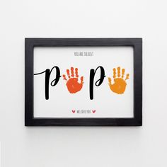 a black frame with two hand prints on it and the words pop written in orange