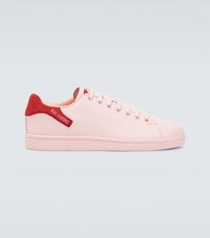 In a classic tennis shoe silhouette, these pastel pink sneakers from Raf Simons feature a silver-tone logo-print detail on red heel counters, and rest on rubber soles. | Raf Simons Orion sneakers Pink Leather High-top Sneakers With Vulcanized Sole, Pink Sneakers With Red Sole For Streetwear, Pink Leather High-top Sneakers With Round Toe, Pink Leather High-top Sneakers With Contrast Sole, Luxury Pink Leather Sneakers, Casual Pink Sneakers With Red Sole, Luxury Pink Lace-up Custom Sneakers, Pink Leather High-top Sneakers With Rubber Sole, Pink Lace-up Sneakers With Leather Sole