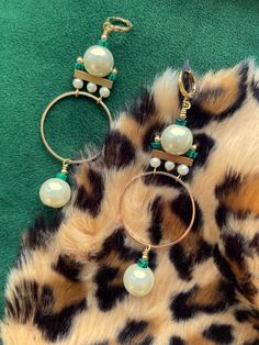 These gorgeous and unique statement hoops were designed in the art deco style of the 1920's. These are the perfect earrings for dressing up your holiday attire.These hoop earrings hang approximately 3.5" from the lobe and measure approximately 1.25" inches at their widest point. The design contains 12mm faux pearls, 4mm faux pearls, 3mm malachite heishi beads, and gold plated brass components.The leverback closure is 22k gold plated and should be suitable for sensitive ears. These are semi-light Bohemian Brass Hoop Earrings For Party, Bohemian Round Hoop Earrings For Party, Elegant Beaded Hoop Earrings For Party, Nickel-free Brass Hoop Earrings For Party, Nickel Free Brass Hoop Earrings For Party, Party Brass Hoop Earrings With Ear Wire, Elegant Metal Hoop Chandelier Earrings, Elegant Metal Chandelier Hoop Earrings, Chic Handmade Dangle Hoop Earrings