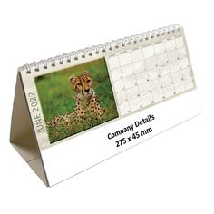 a desk calendar with an image of a cheetah in the grass on it