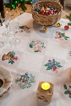 a table topped with plates and candles next to a basket filled with christmas candies