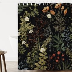 a black shower curtain with flowers and plants on the wall next to a wooden stool