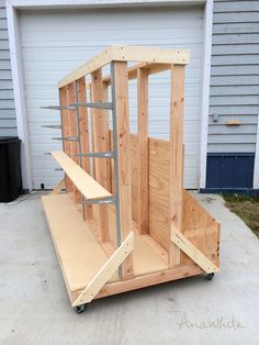 a wooden structure sitting on top of a cement floor next to a garage door and window