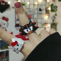 a person wearing a hello kitty ring on their left hand and a hello kitty bracelet on her right wrist