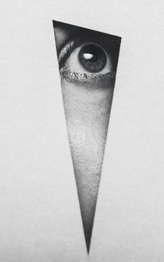 an eye is seen through a hole in the paper