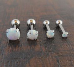 three different types of piercings sitting on top of a wooden table