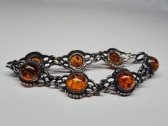 This vintage cabochon sterling silver amber bracelet weighs 17.03 g. The length is 7 inches long. There are 7 double link cabochon amber. On the back side of each cabochon amber link it is marked 925 and V-8. It is tarnished. It has a spring ring clasp.  Each item listed will be clean with soap and water. Some sterling may be polished. Everything listed is the best of my knowledge. Feel free to reach out to me with any questions or concerns. Vintage Baltic Amber Jewelry For Formal Occasions, Adjustable Amber Bracelet For Formal Occasions, Adjustable Amber Jewelry For Formal Occasions, Vintage Sterling Silver Cabochon Bracelets, Vintage Sterling Silver Bracelets With Cabochon, Formal Baltic Amber Cabochon Jewelry, Formal Round Baltic Amber Jewelry, Formal Baltic Amber Jewelry, Vintage Cabochon Bracelets For Formal Occasions