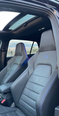 the interior of a car with leather seats and blue stitching on the front seat