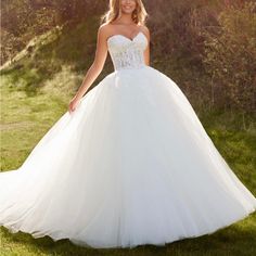 a woman in a white wedding dress posing for the camera