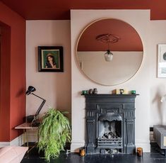 a living room with a fire place and mirror