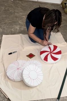 a woman sitting on top of a white sheet next to two large candy canes