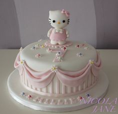 a hello kitty cake with pink and white decorations