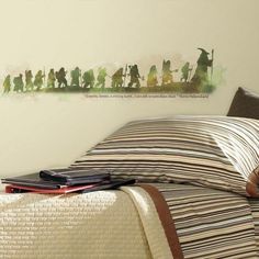 a bed with a striped comforter on top of it next to a wall mural