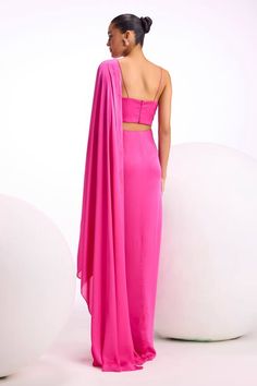 Fuchsia pre-draped saree with asymmetric front pleats. Comes with tonal sequin, floral pattern hand embellished blouse. - Aza Fashions Pre-draped Pink Gown For Gala, Pink Draped Satin Evening Dress, Pink Pre-draped Gown With Ruched Bodice, Pink Satin Pre-draped Evening Dress, Pink Pre-draped Gown With Fitted Bodice, Pink Pre-draped Silk Evening Dress, Pink Draped Fitted Gown, Pink Fitted Draped Gown, Pink Draped Evening Dress With Fitted Bodice