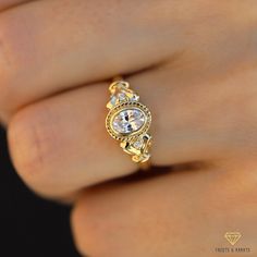 a woman's hand with a yellow gold ring on it and a diamond in the middle