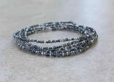 This is a lovely 36 inch long size 11/0 Morning Fog Tiny seed bead wrap bracelet. The colors used are shades of grey, clear, and silver. I've used stretch cord for this bracelet. 11/0 seed beads are 2mm by 2mm with the hole a diameter of 1mm. Bohemian Silver Wrap Bracelet With Faceted Beads, Bohemian Silver Wrap Bracelet With Spacer Beads, Gray Faceted Beads Bracelet As Gift, Gray Faceted Beads Bracelet For Gift, Gray Beaded Bracelets With Faceted Beads As A Gift, Gray Faceted Beaded Bracelets As Gift, Gray Faceted Beaded Bracelets For Gifts, Handmade Silver Multi-strand Wrap Bracelet, Silver Wrap Bracelet With Tiny Beads For Gift