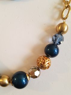 "This Fabulous Vintage Gilded Unsigned Brighton Gold Necklace is made with chains and beads. The beads are in gold, facet light blue, solid Royal Blue, gilded gold metal cut-out round bead, round facet clear topaz bead and a square transparent blue glass bead. The pattern is identical on the other side. The necklace is long so you can twist it again and double it. The chain is a solid oval and a textured oval gilded gold metal chain links. At the end is a heart shaped lobster clasp. The necklace Elegant Blue Chain Necklace For Party, Blue Polished Bead Jewelry For Parties, Blue Polished Beads Jewelry For Party, Blue Polished Beads Party Jewelry, Elegant Blue Beaded Necklaces With Chain, Gold Metal Jewelry With Faceted Beads, Gold Jewelry With Large Beads For Party, Gold Beaded Jewelry For Parties, Gold Metal Beaded Necklaces With Large Beads