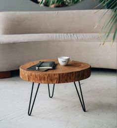 a coffee table with some books and a cup on it in front of a couch