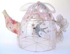 a bird in a cage with flowers and buttons on its head is shown from the side