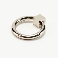 a silver ring with two rings around it on a white surface and one is in the middle