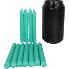 several green candles are next to a black container and one is full of matchesticks