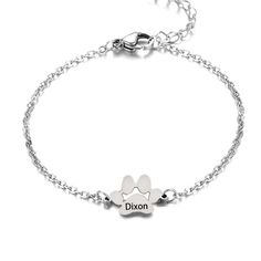 a silver bracelet with two paw prints and the word dixion written on it